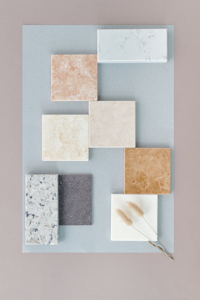 about-us-01 Flat lay of various marble tiles arranged on a soft neutral backdrop for design inspiration.